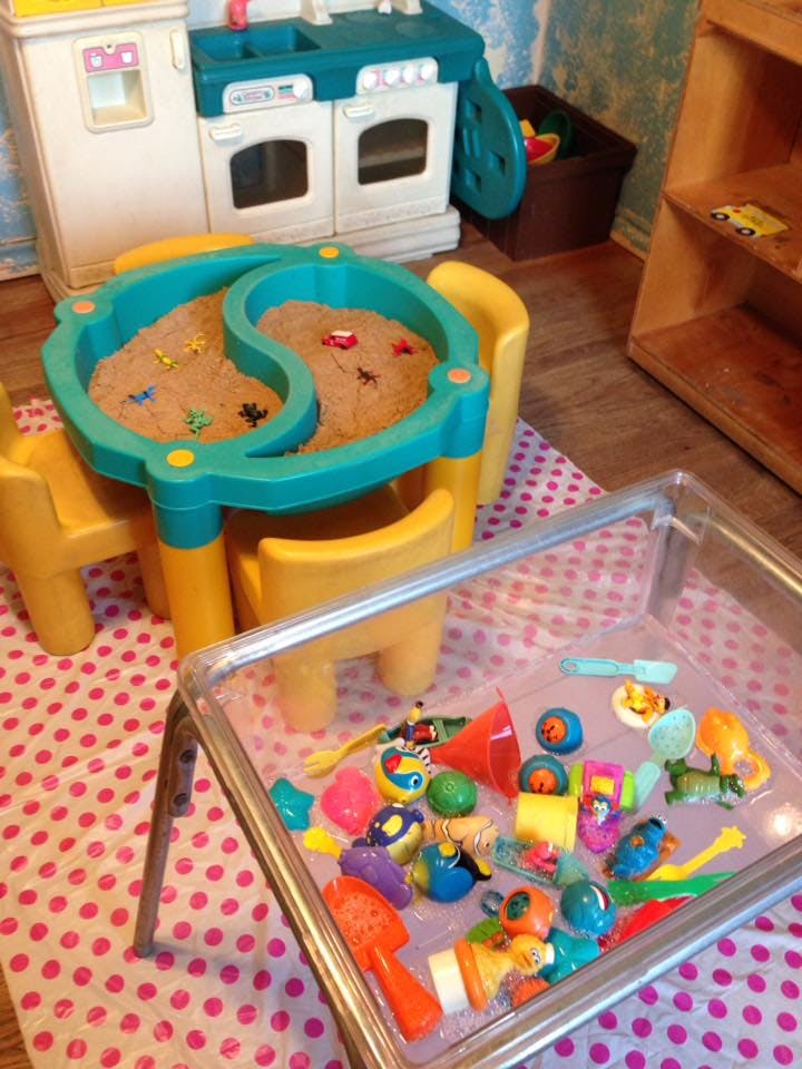 Playroom with a sand table and a sensory bin filled with toys