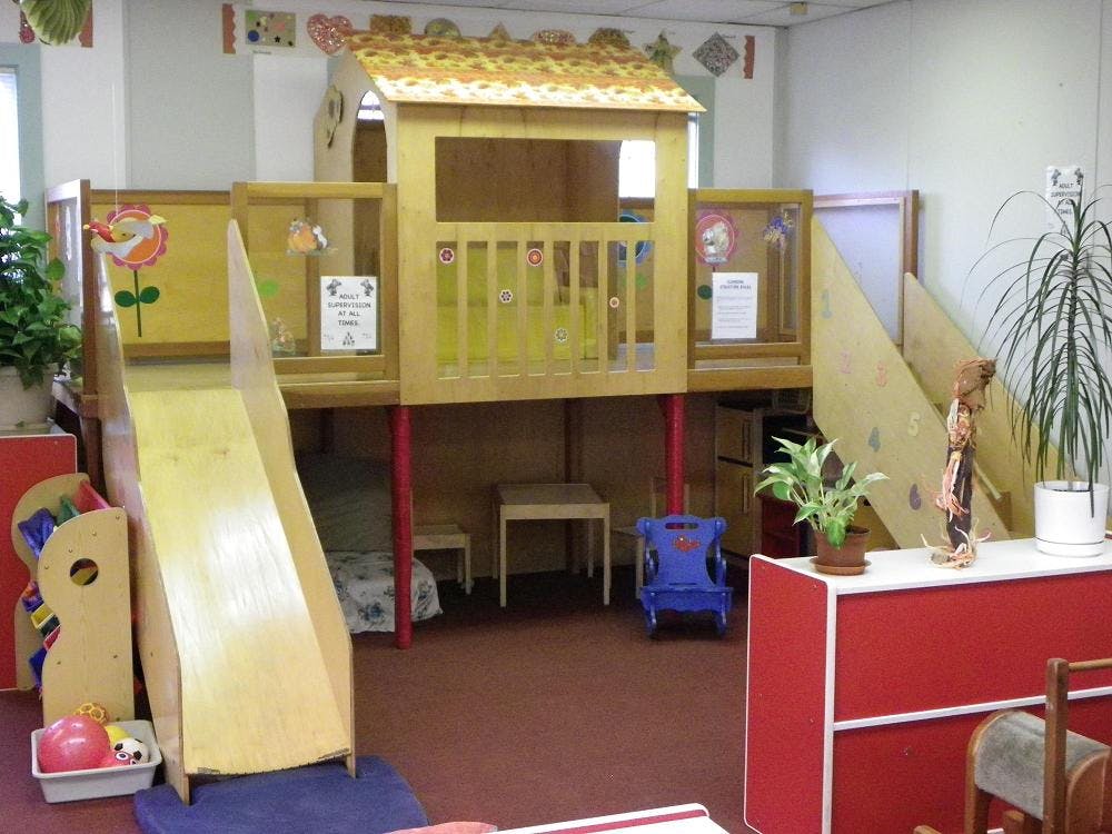 Indoor play structure with a slide and stairs