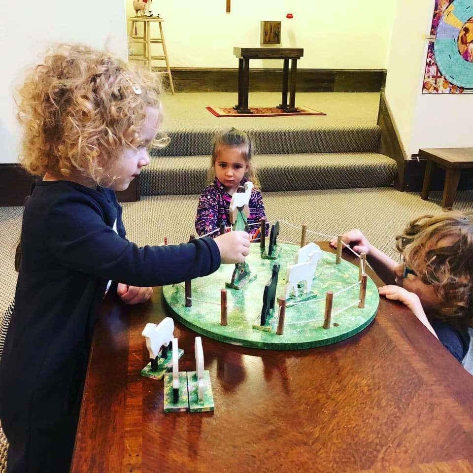 Three children playing with a board game on a table