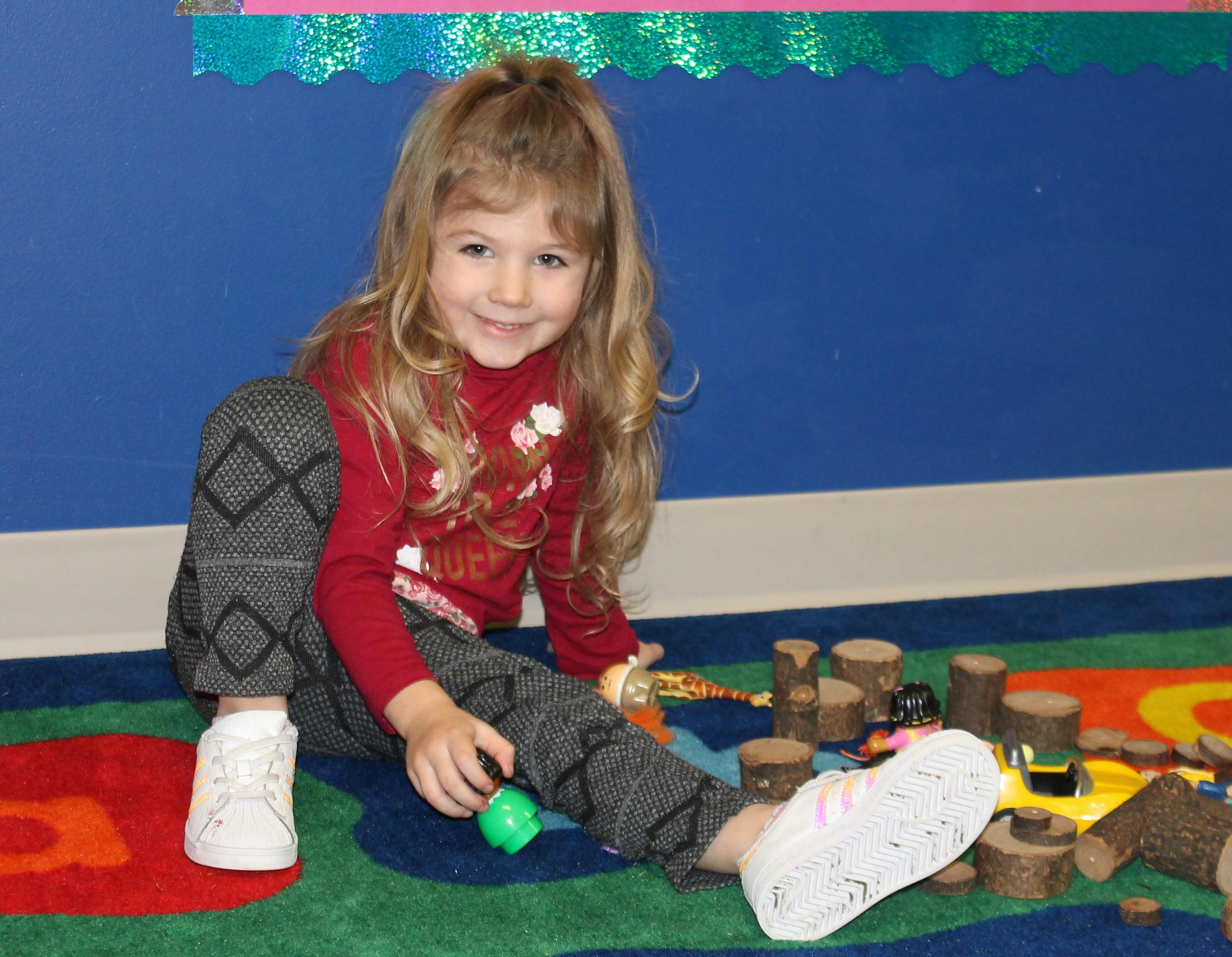 Child sitting on floor playing with toys