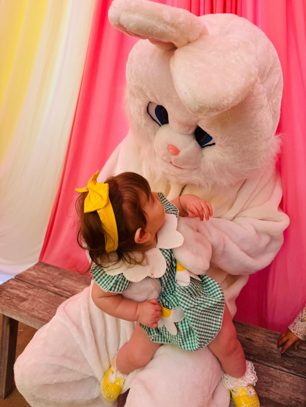 Child sitting on person in a rabbit costume