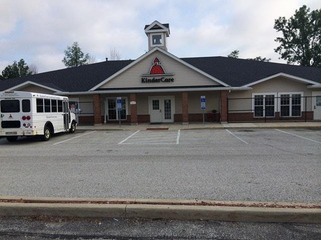 KinderCare building with a parked white bus in front