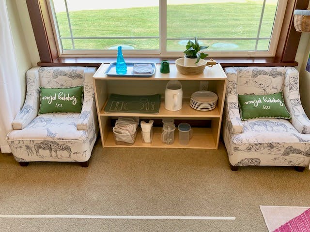 Two armchairs with a wooden shelf unit between them