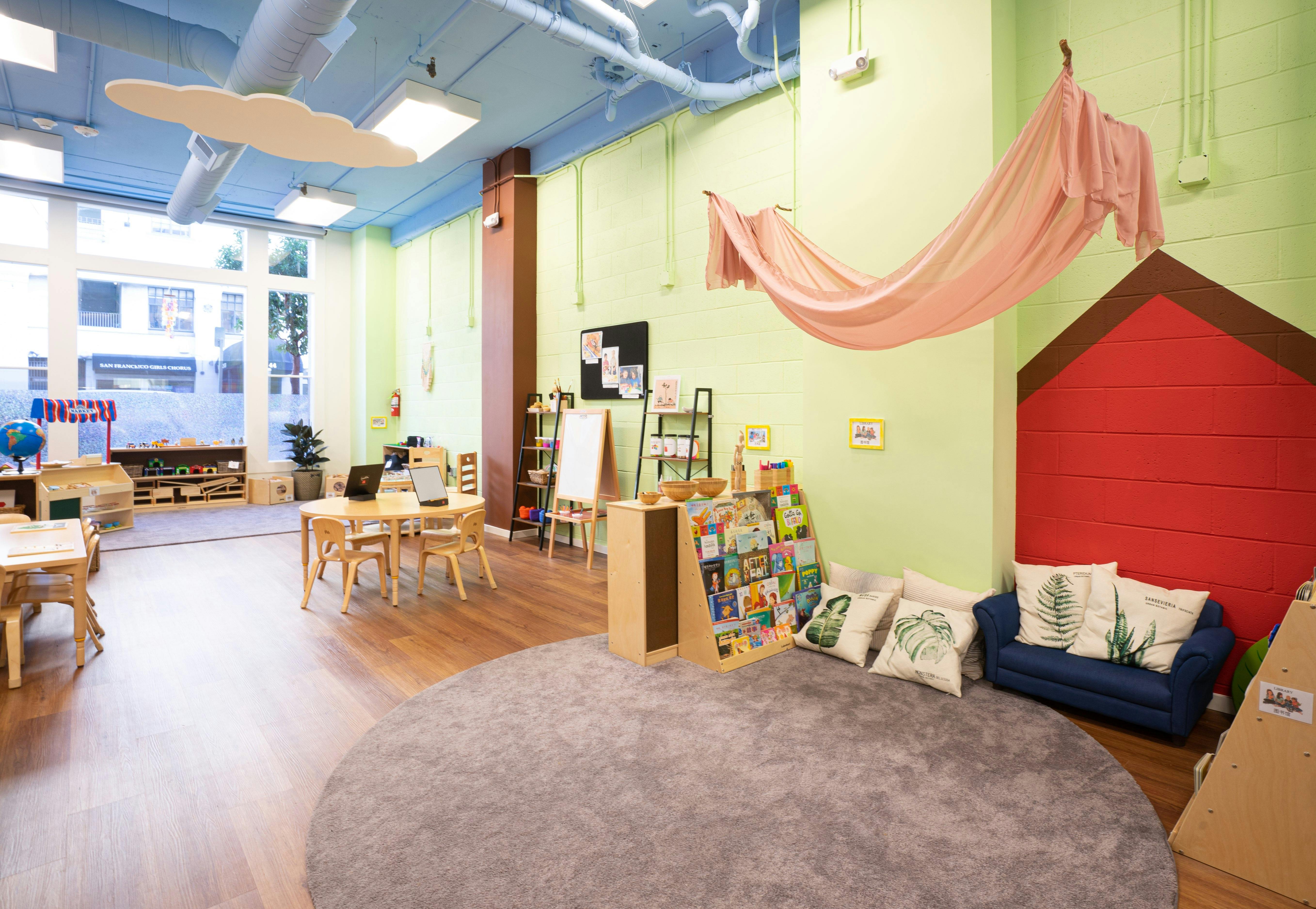 Classroom with tables, chairs, and a reading nook with a blue couch
