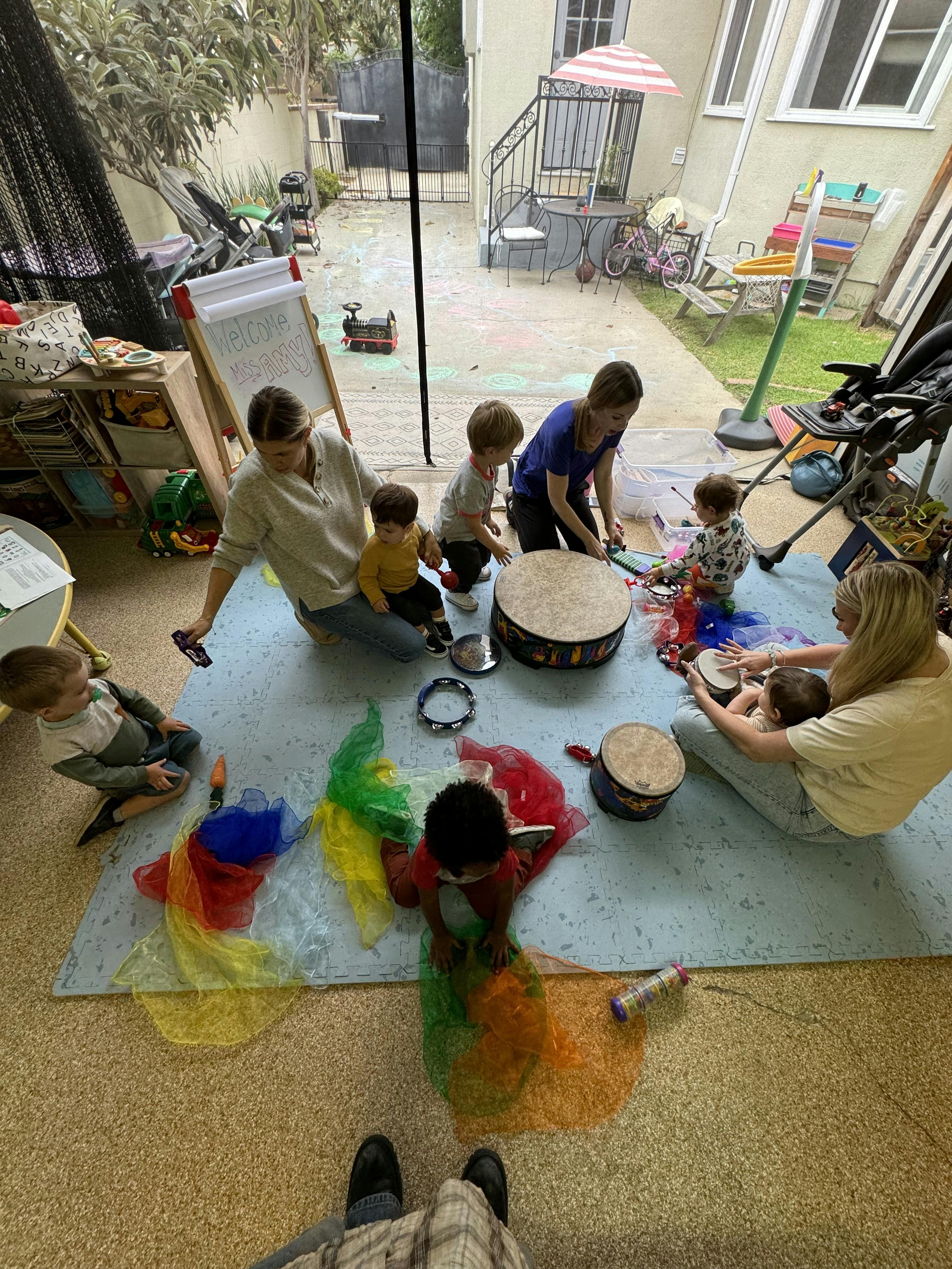People and children playing with musical instruments and colorful scarves