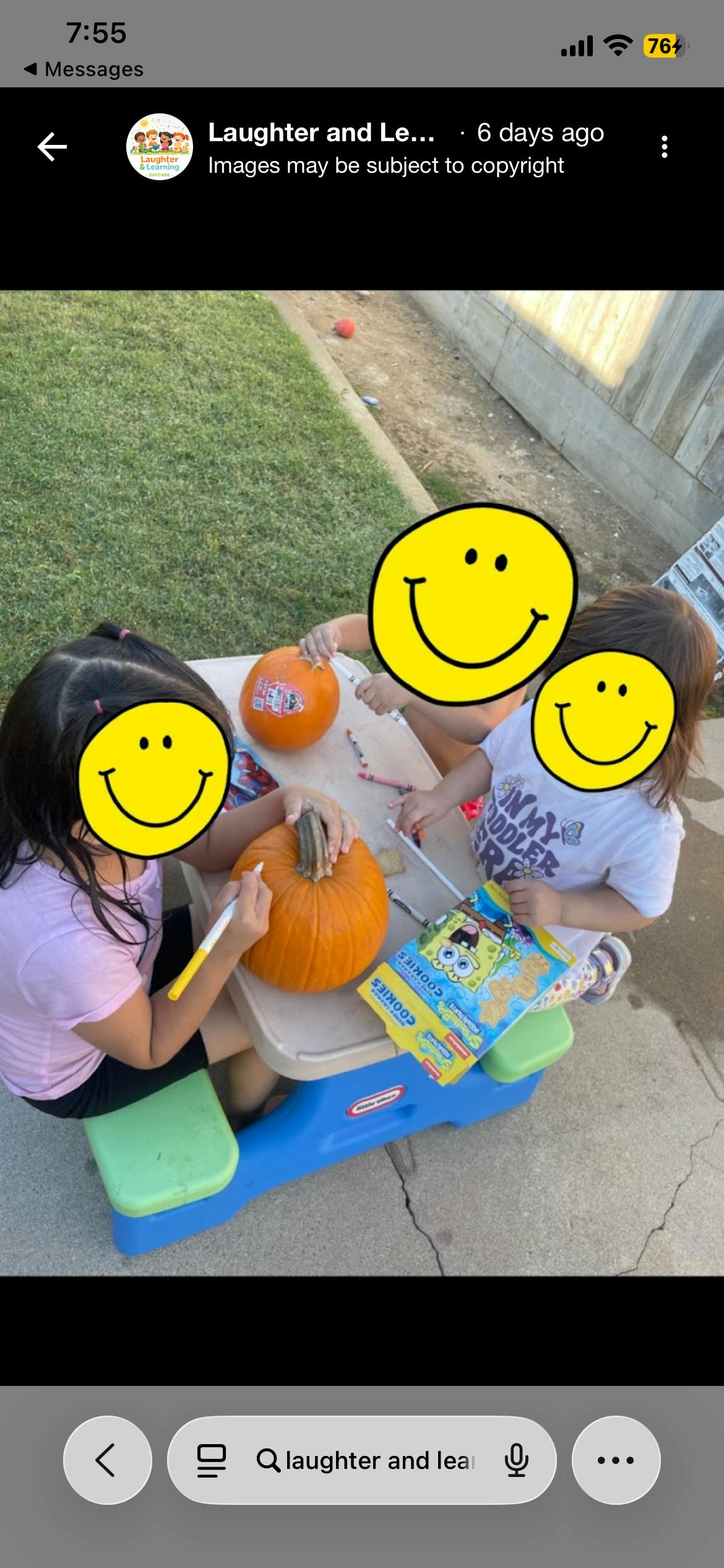 two children decorating pumpkins at a small table outdoors