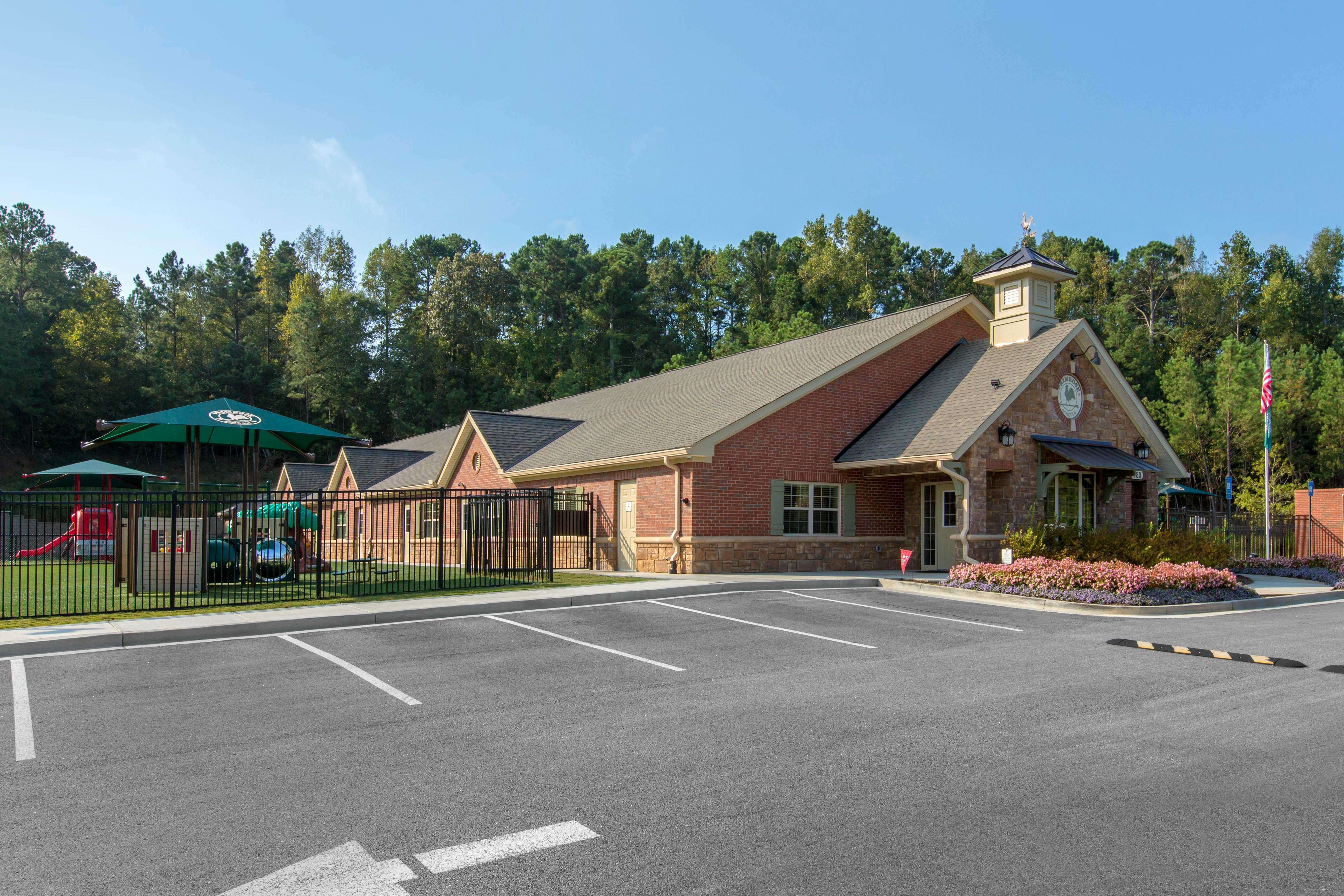 Brick building with a playground and parking lot in front