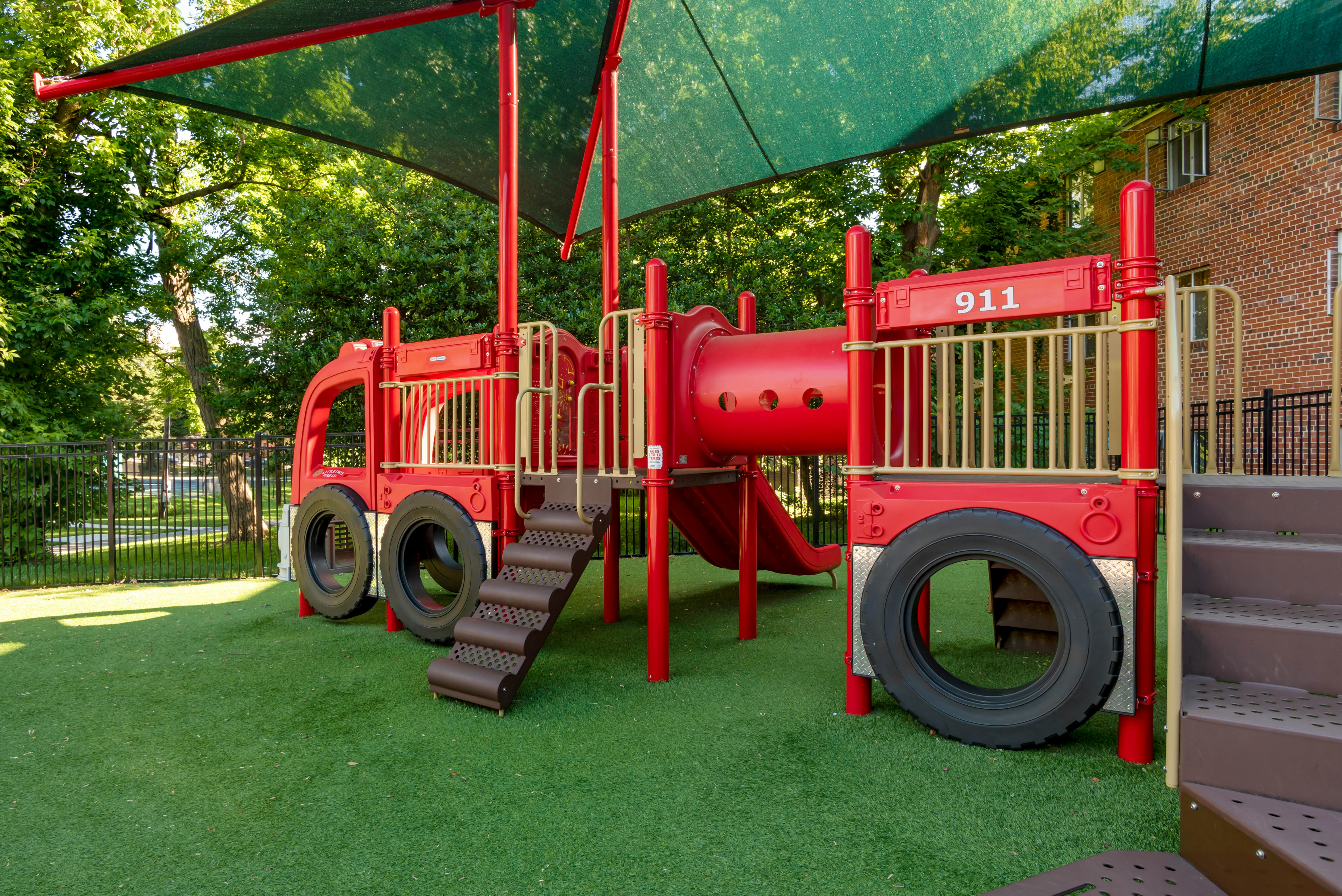 Red fire truck-themed playground equipment with slides and climbing areas