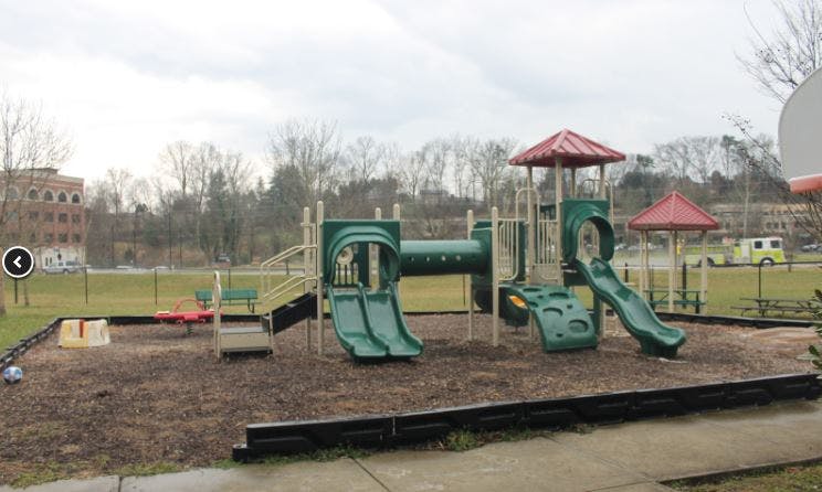 Empty playground with green slides and red roofs