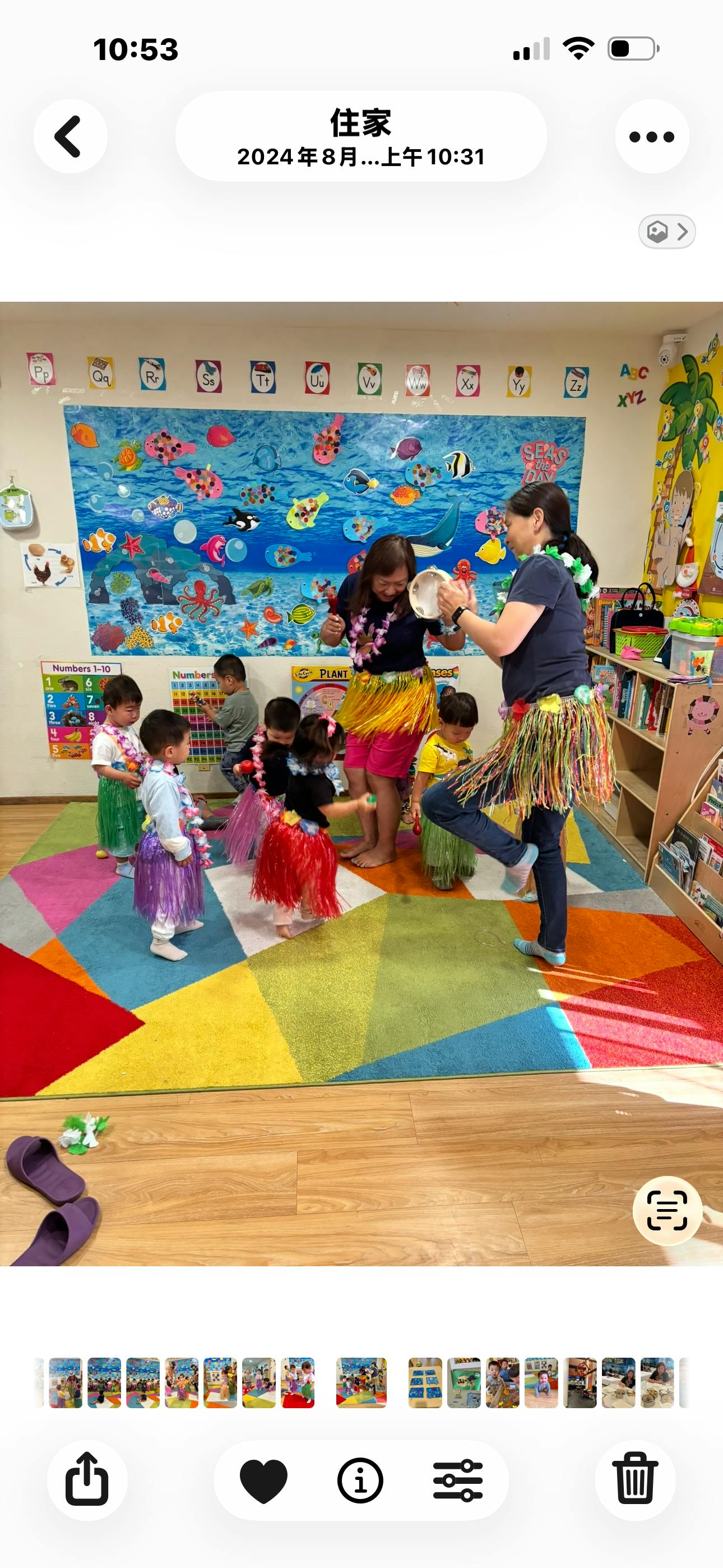 People and children dancing in hula skirts in a classroom
