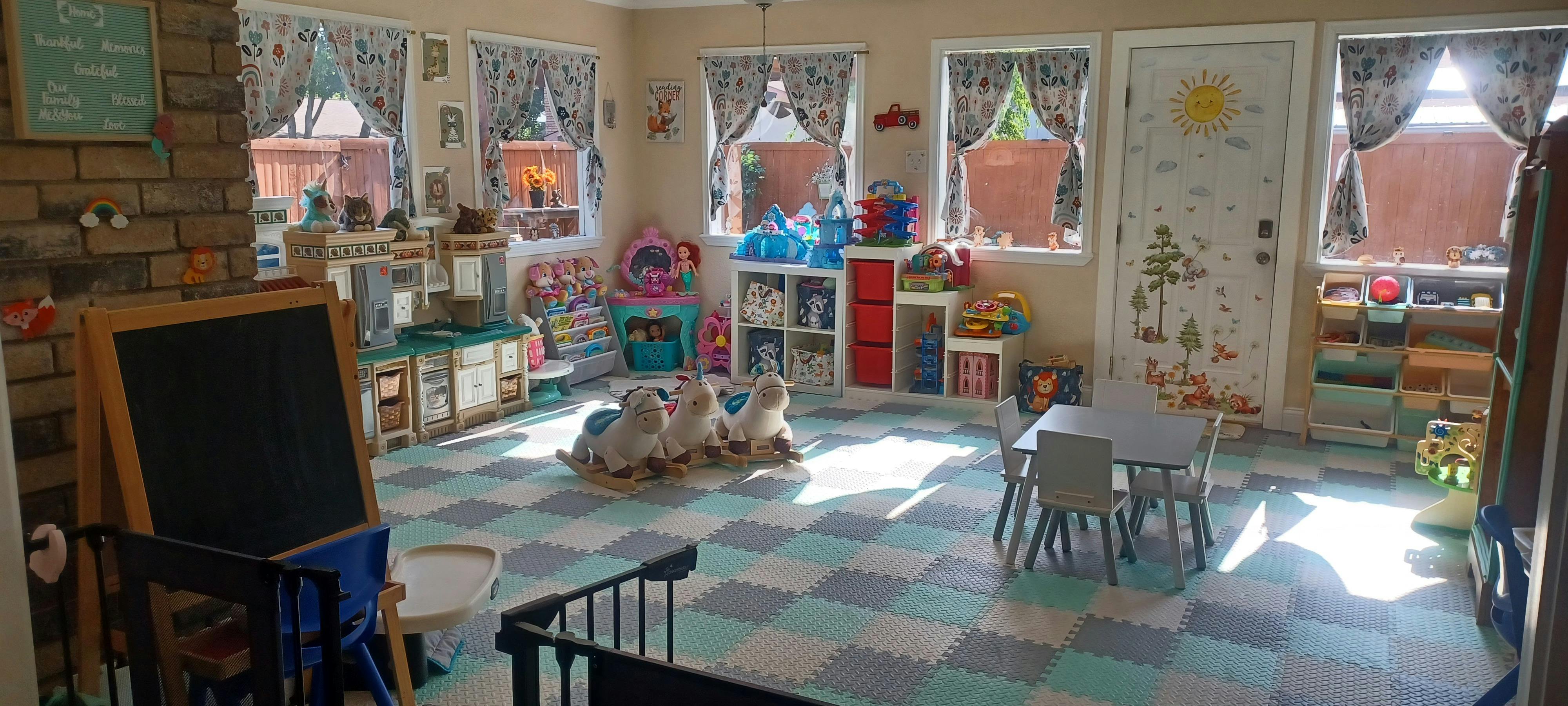 Playroom with rocking horses and a small table and chairs on a tiled floor