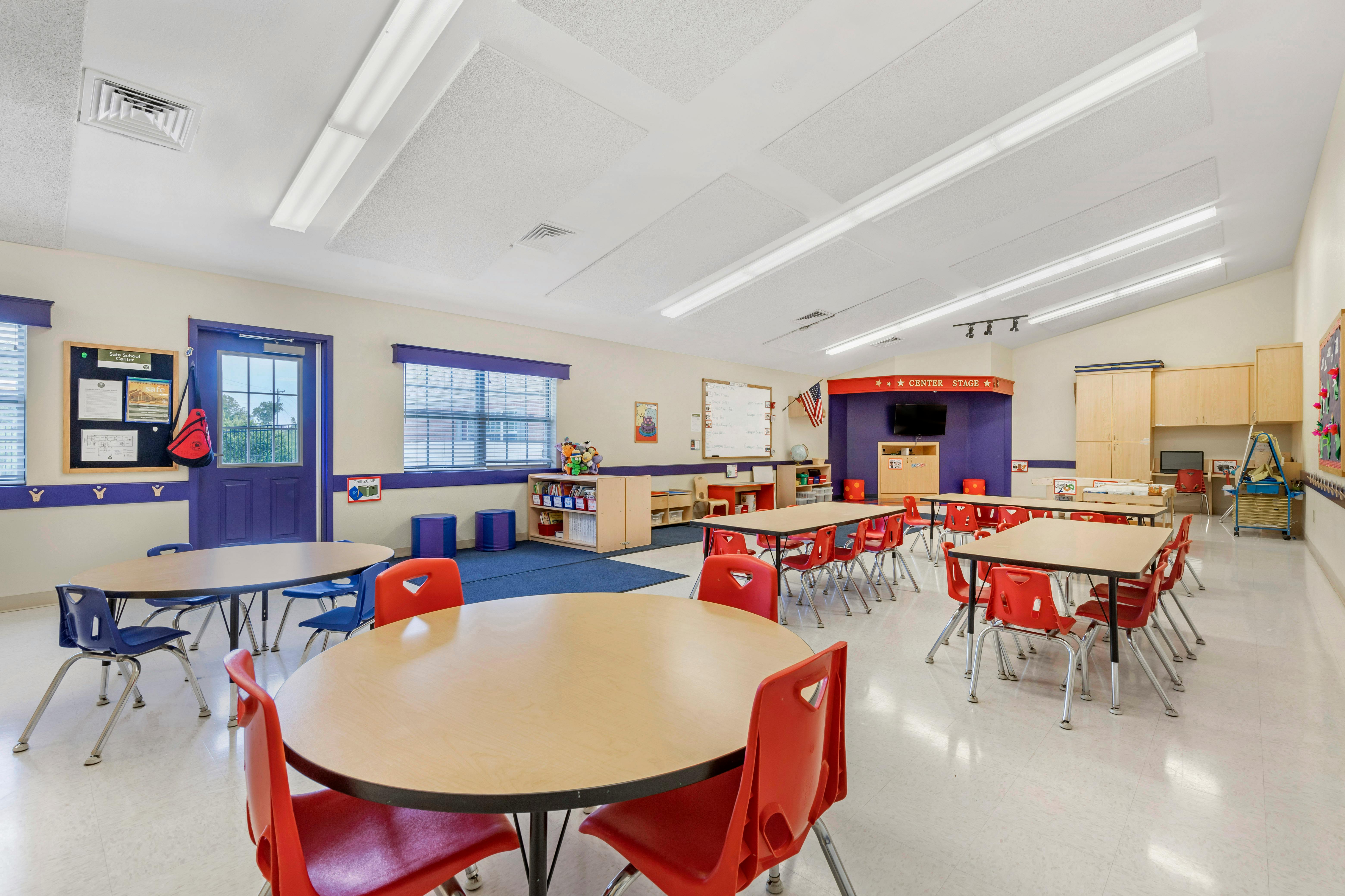 Classroom with child-sized tables and chairs, whiteboards, and learning areas
