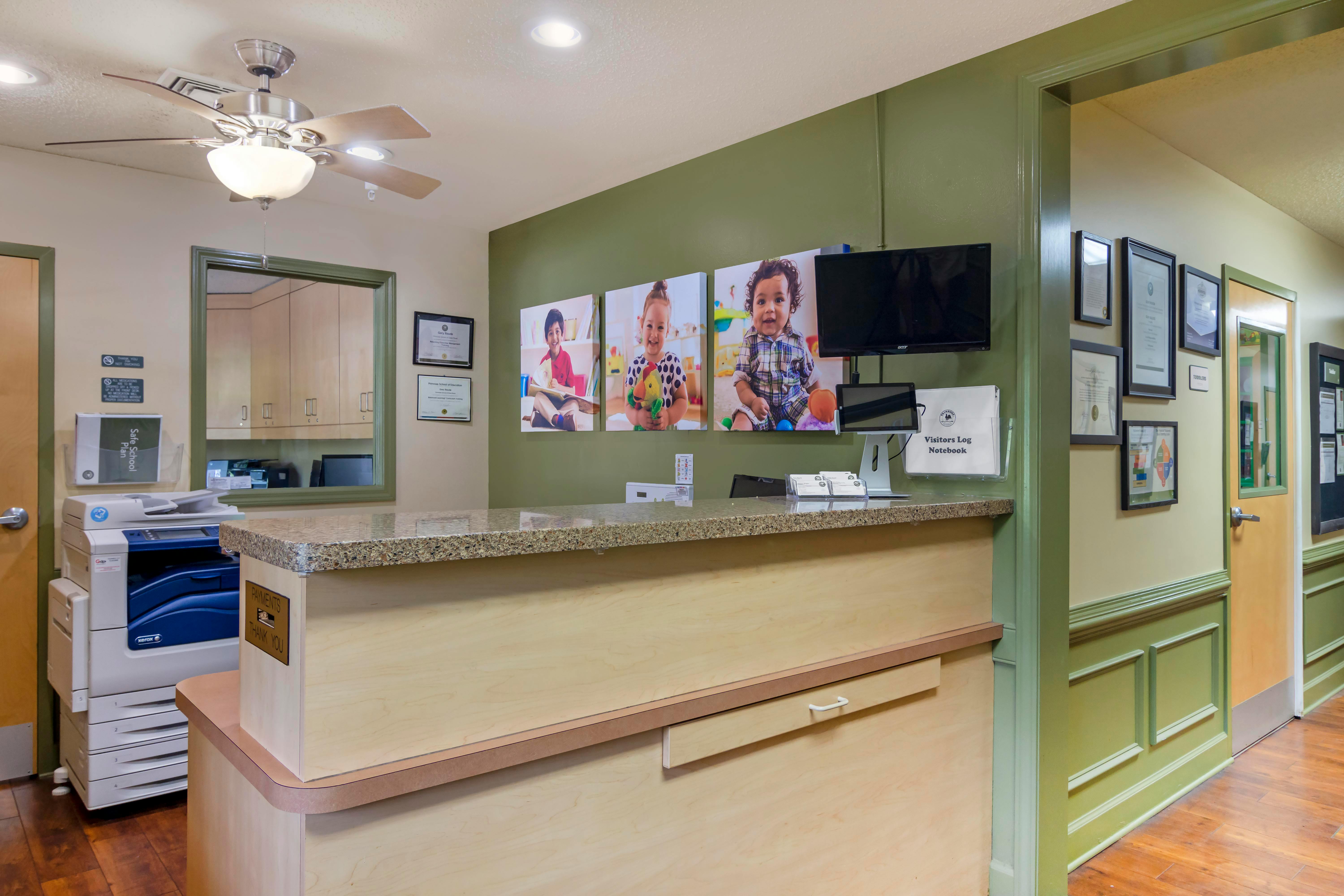 Reception desk with photos of children on the wall