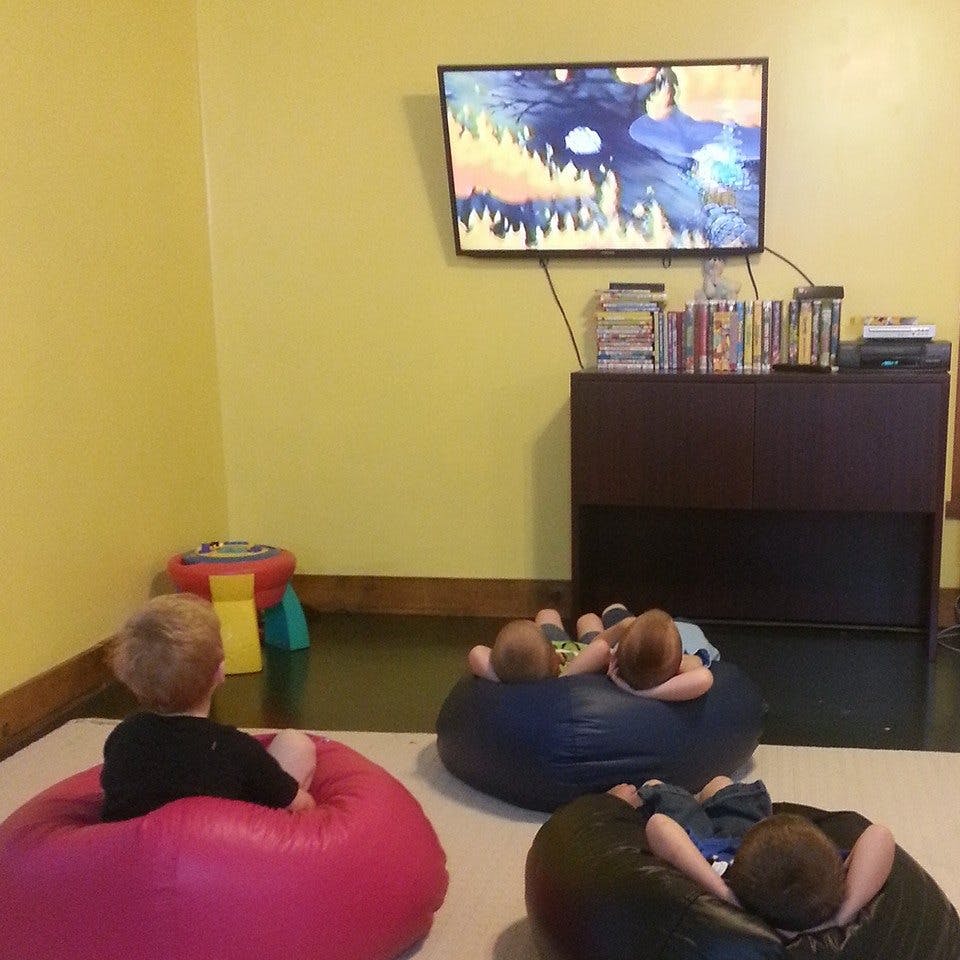 Children watching television while sitting on beanbag chairs