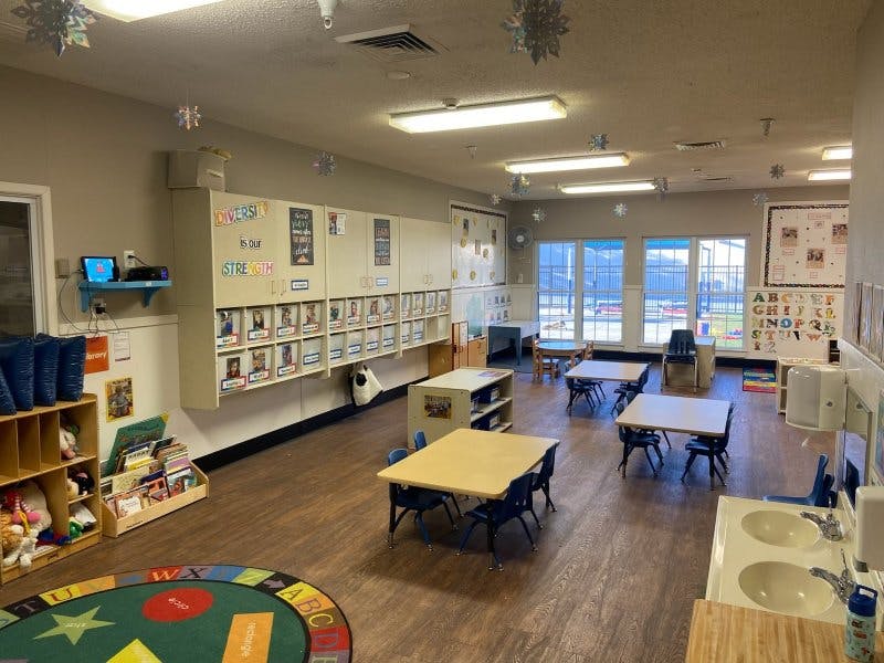 Classroom with small tables and chairs, shelves, and windows