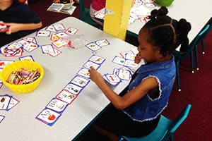 Child playing a card game at a table