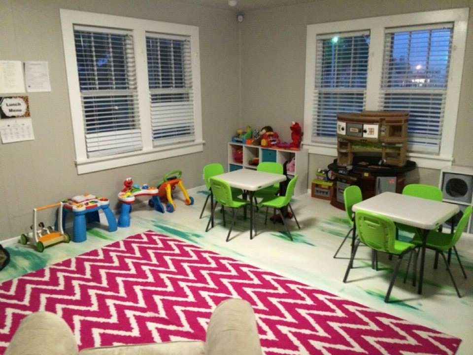 Playroom with small tables and chairs, toys, and a pink chevron rug