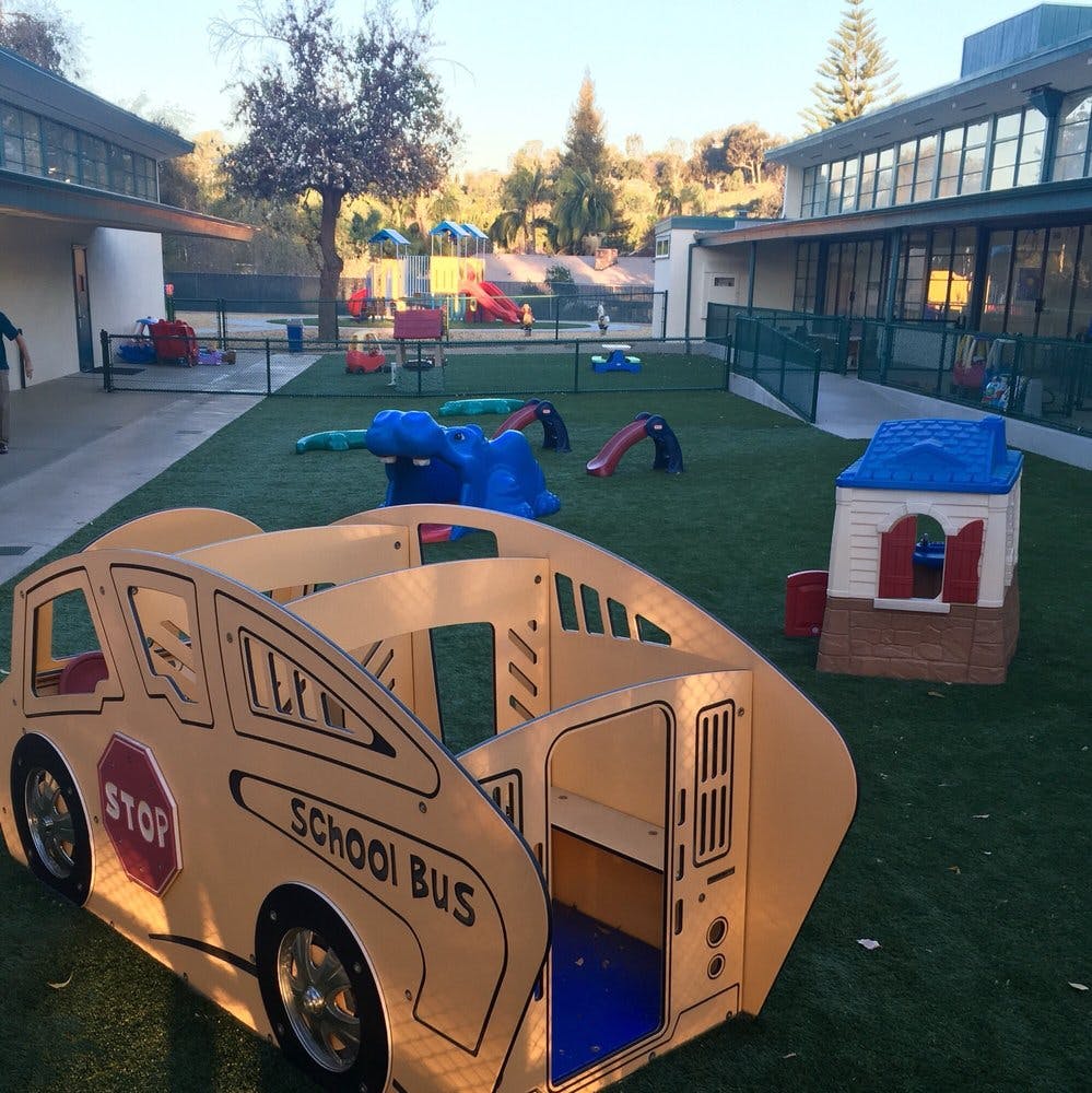 Playground with a school bus play structure and other play equipment