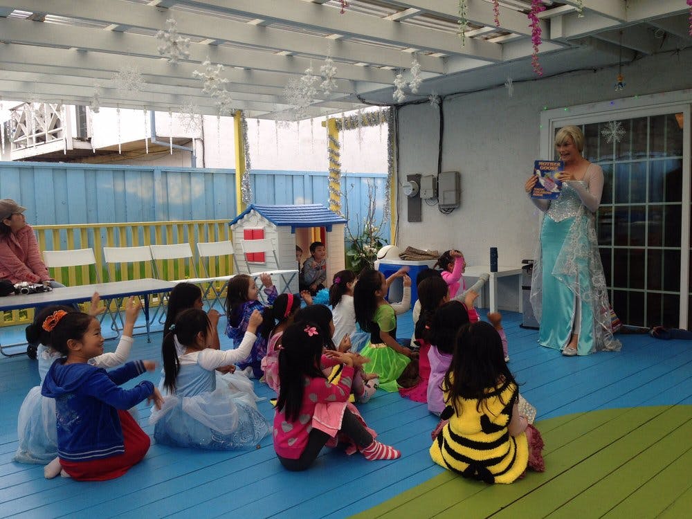 Person in costume reading to a group of children