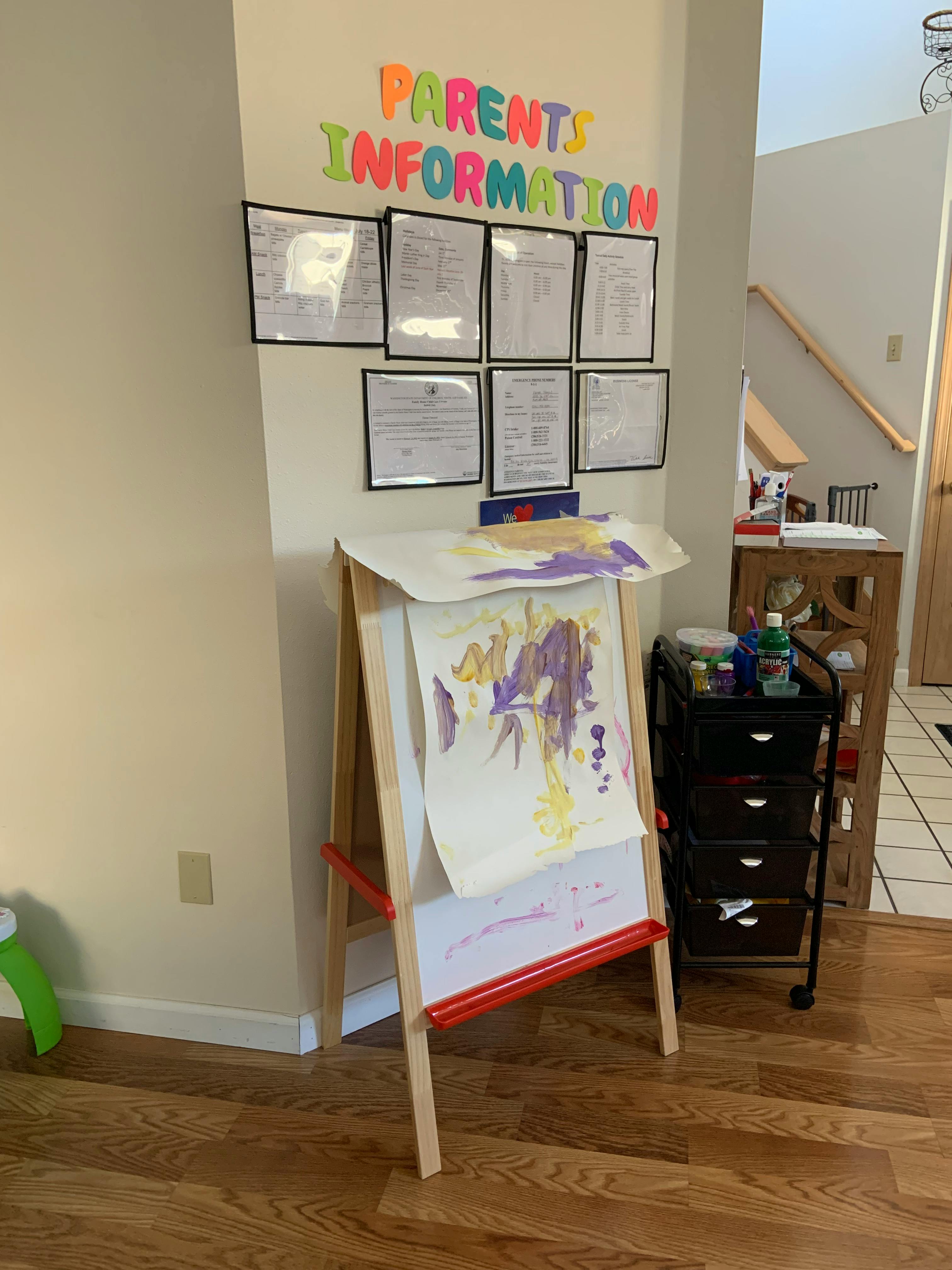 Parent Information sign above an easel with a child's painting