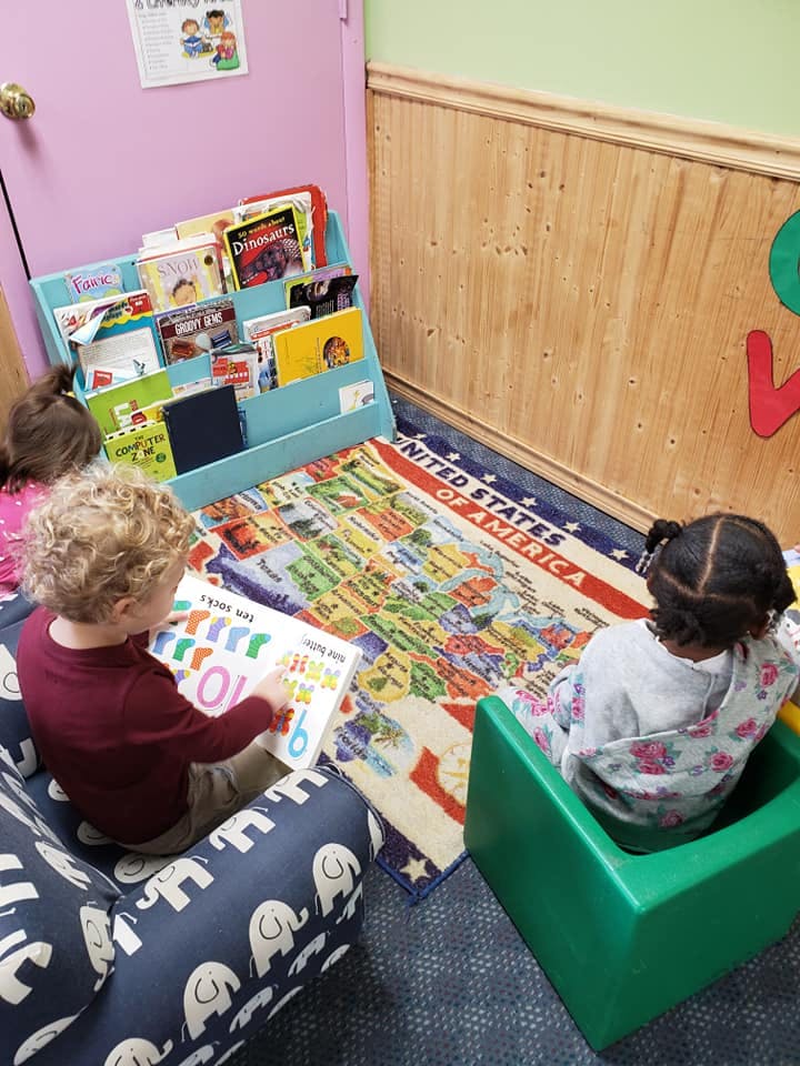 Two children reading books in a classroom