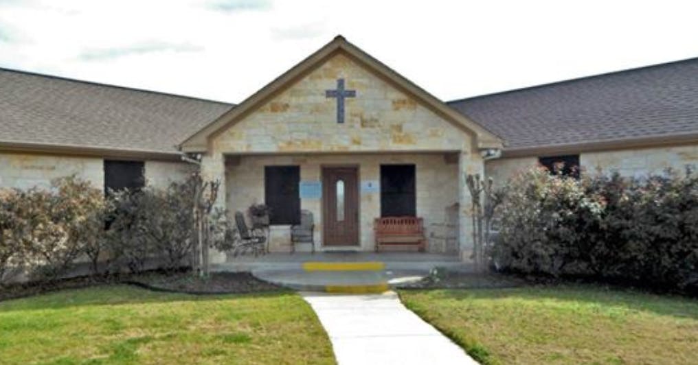 Building with a cross on the facade and a walkway leading to the entrance