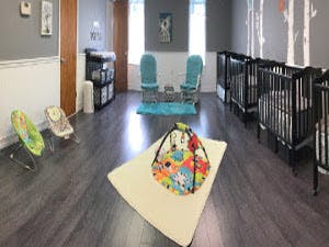 Nursery room with cribs, changing station, and infant seats