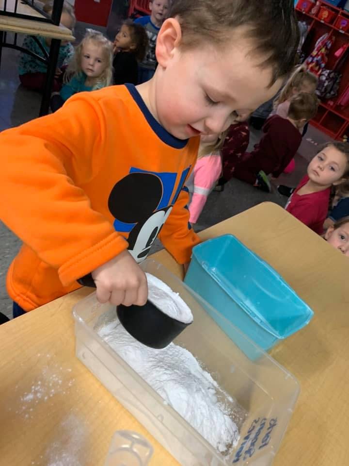 Child scooping white powder from a container