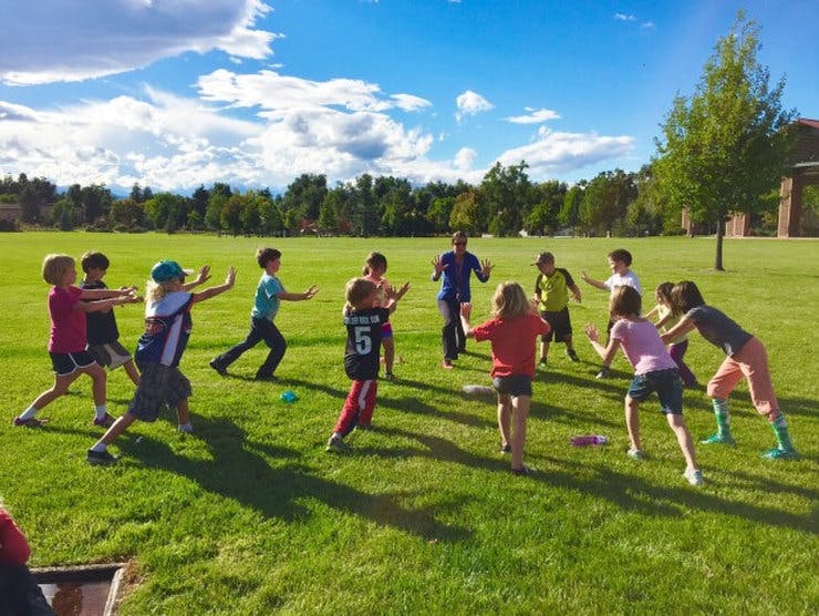Children playing a game in a grassy field