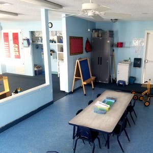 Classroom with tables, chairs, and an easel