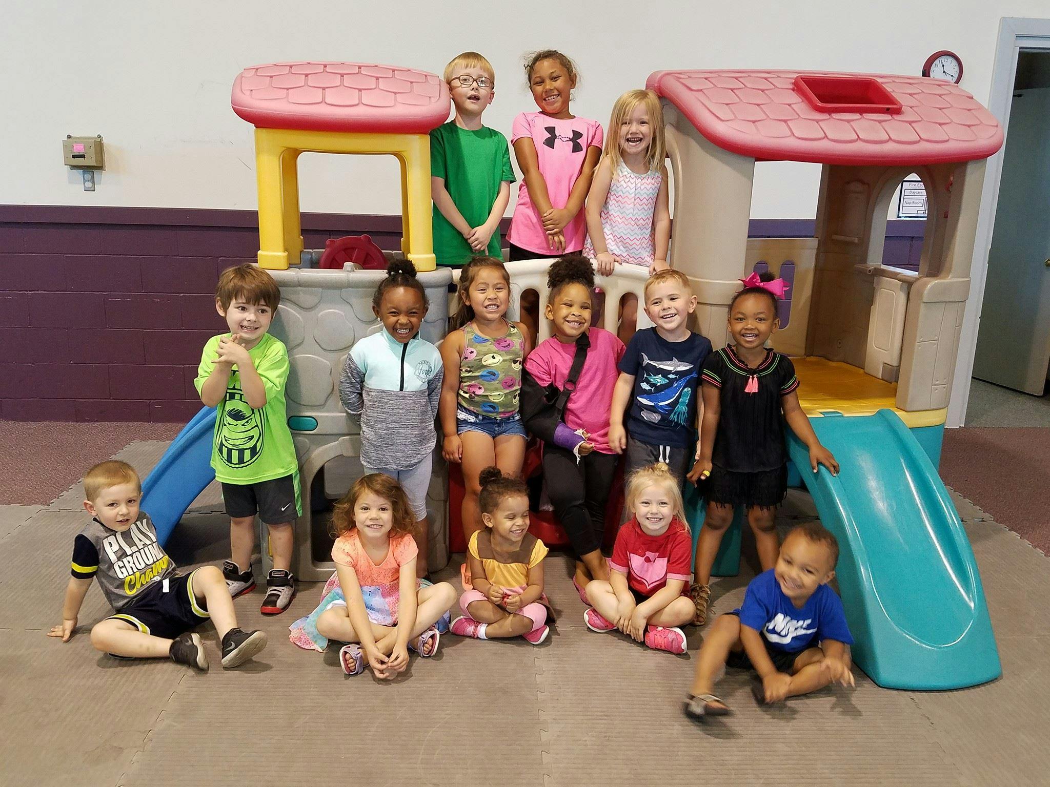 Group of children posing in front of a play structure