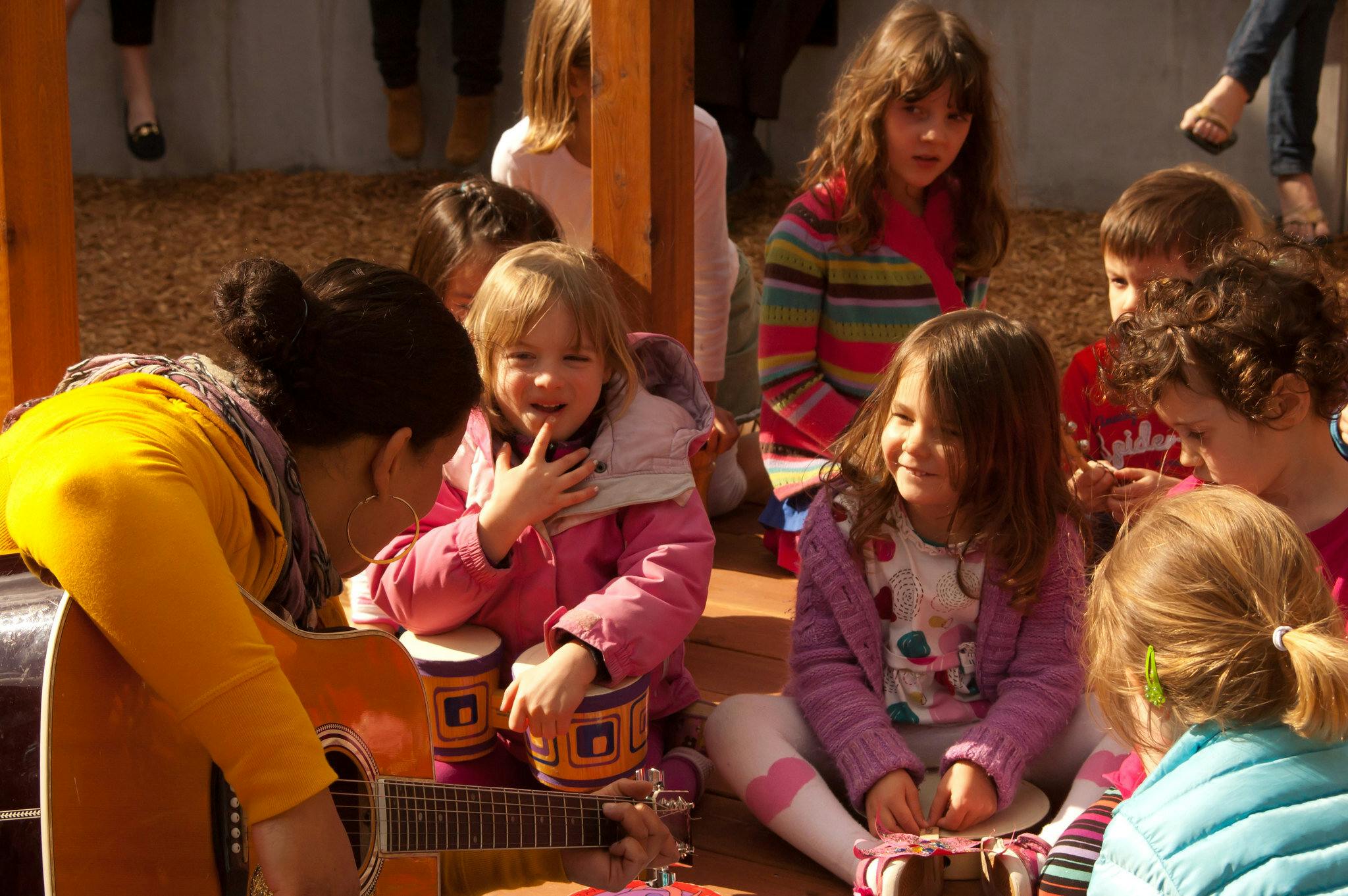 Person playing guitar for a group of children