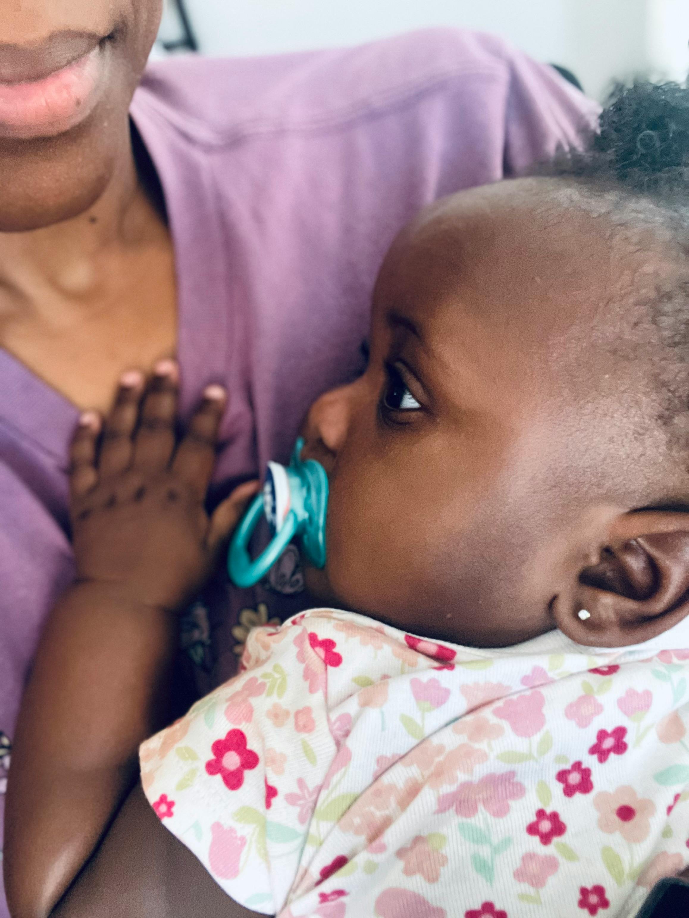 Person holding a child with a pacifier
