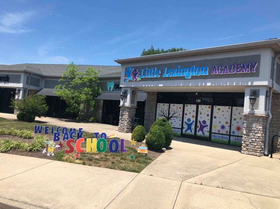 Building with "Welcome Back to School" sign and "Little Lexington Academy" sign