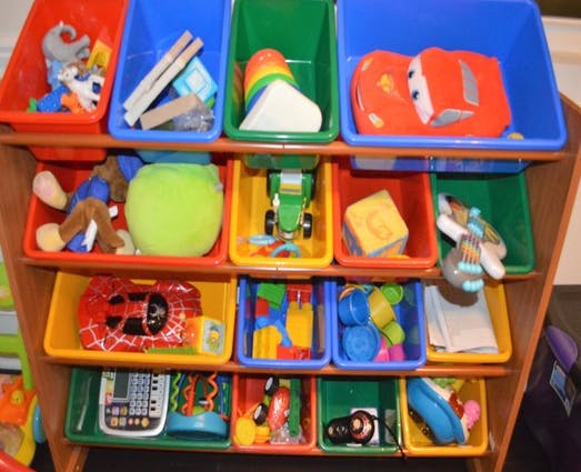 Toy organizer with multiple colorful bins filled with various toys