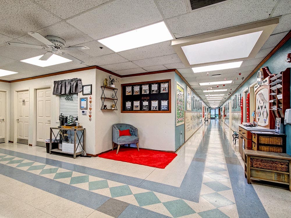 A long brightly lit hallway with patterned floor tiles and decorations