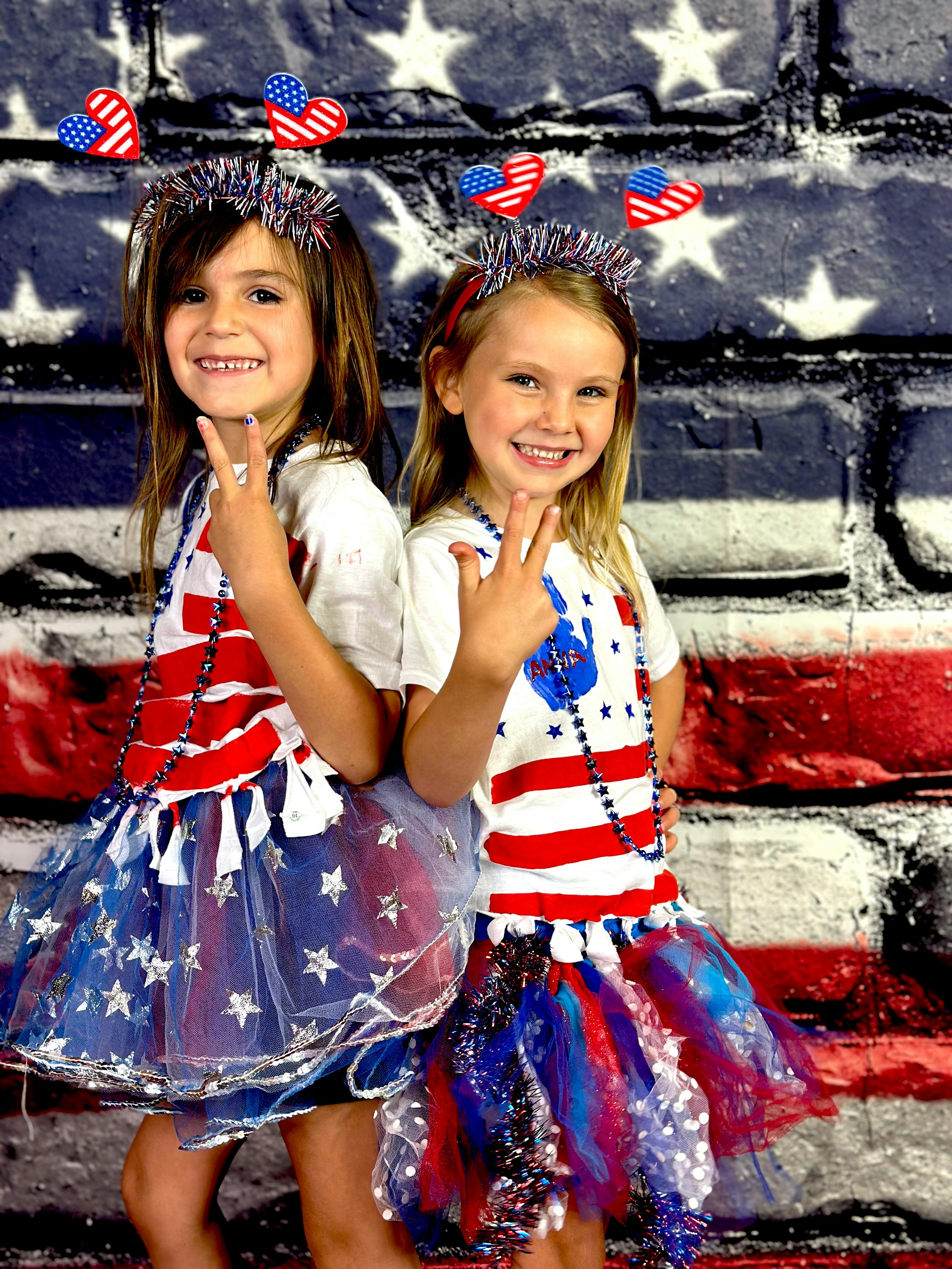 Two children in patriotic outfits making peace signs