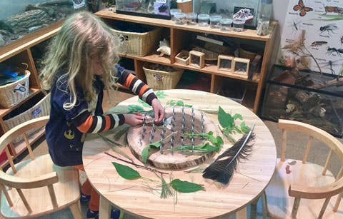 Child playing with natural materials on a round table