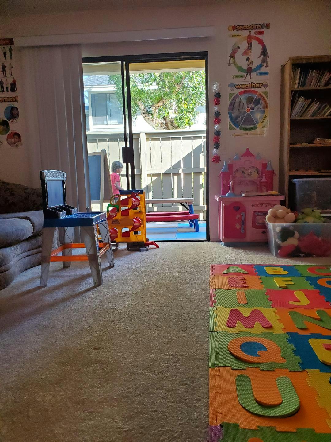Child standing in a doorway with toys in a room