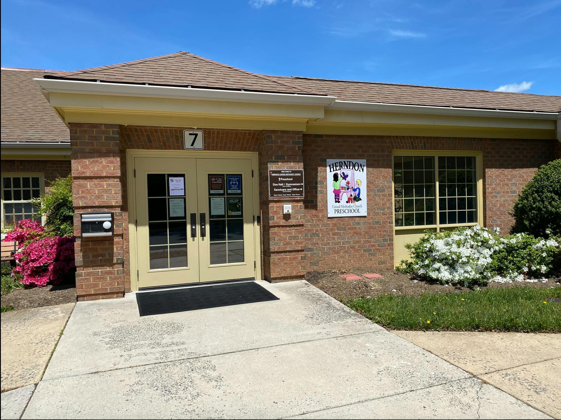 Brick building with double glass doors and a sign with the number 7 above