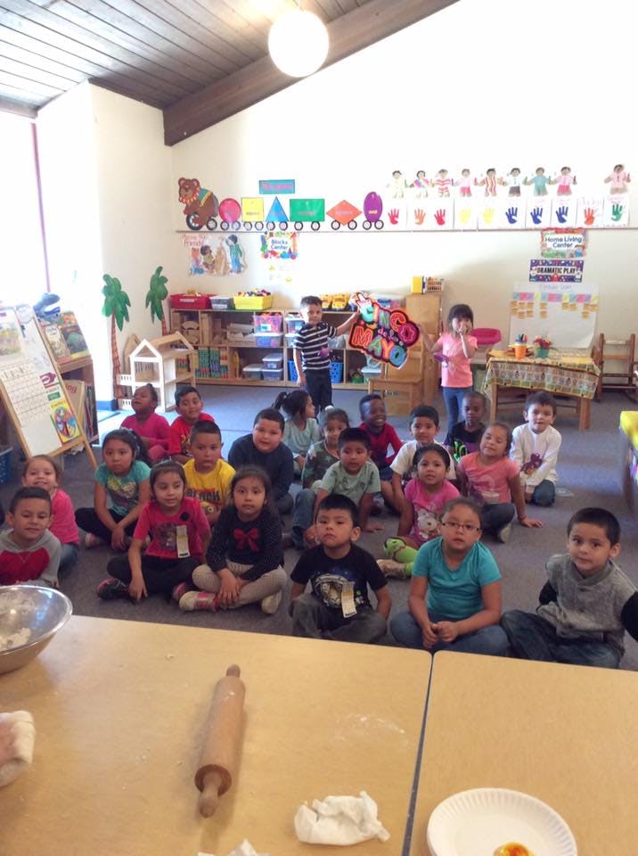 Group of children sitting on the floor in a classroom