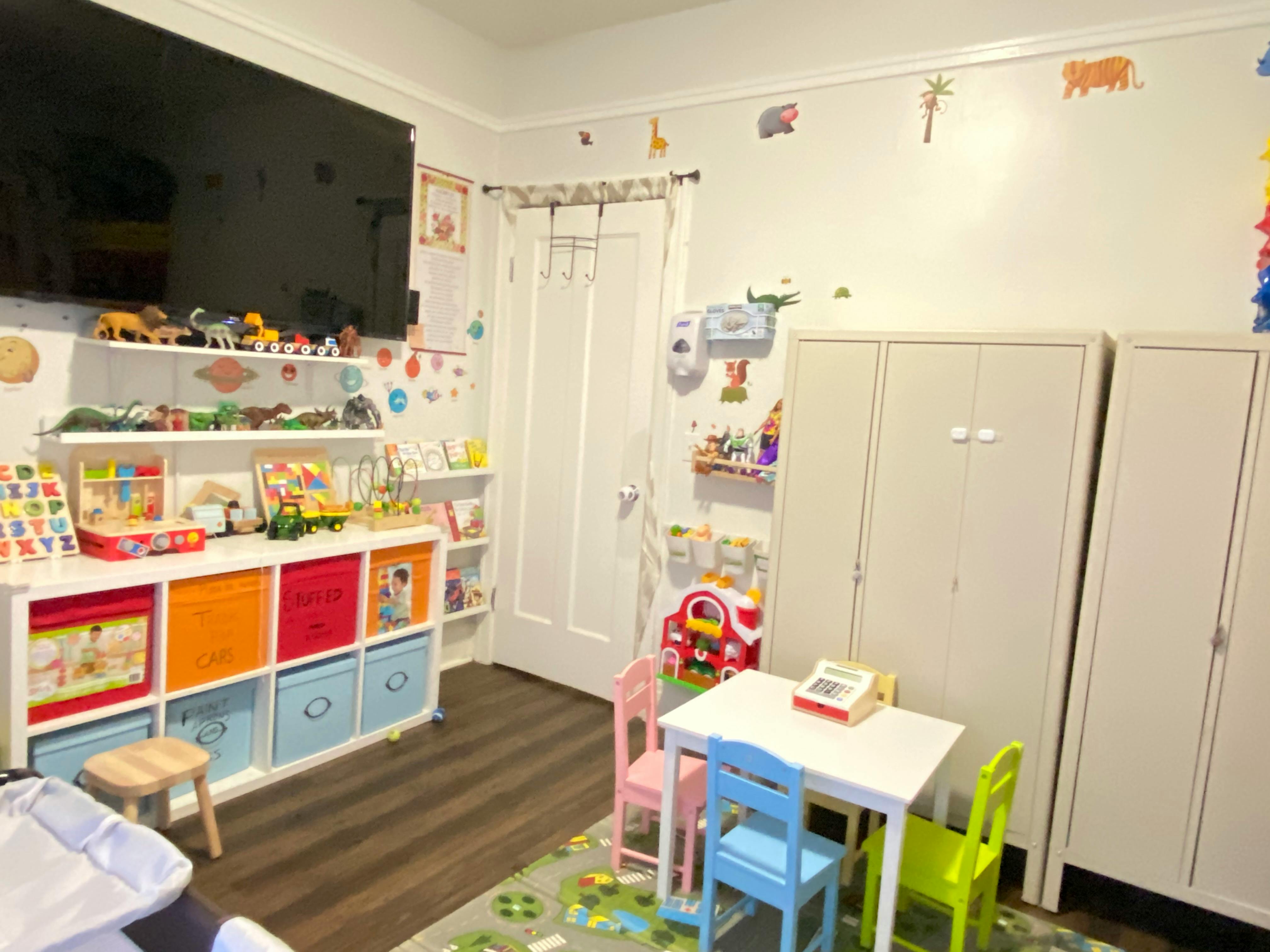 Playroom with toy storage, small table and chairs, and wall decorations
