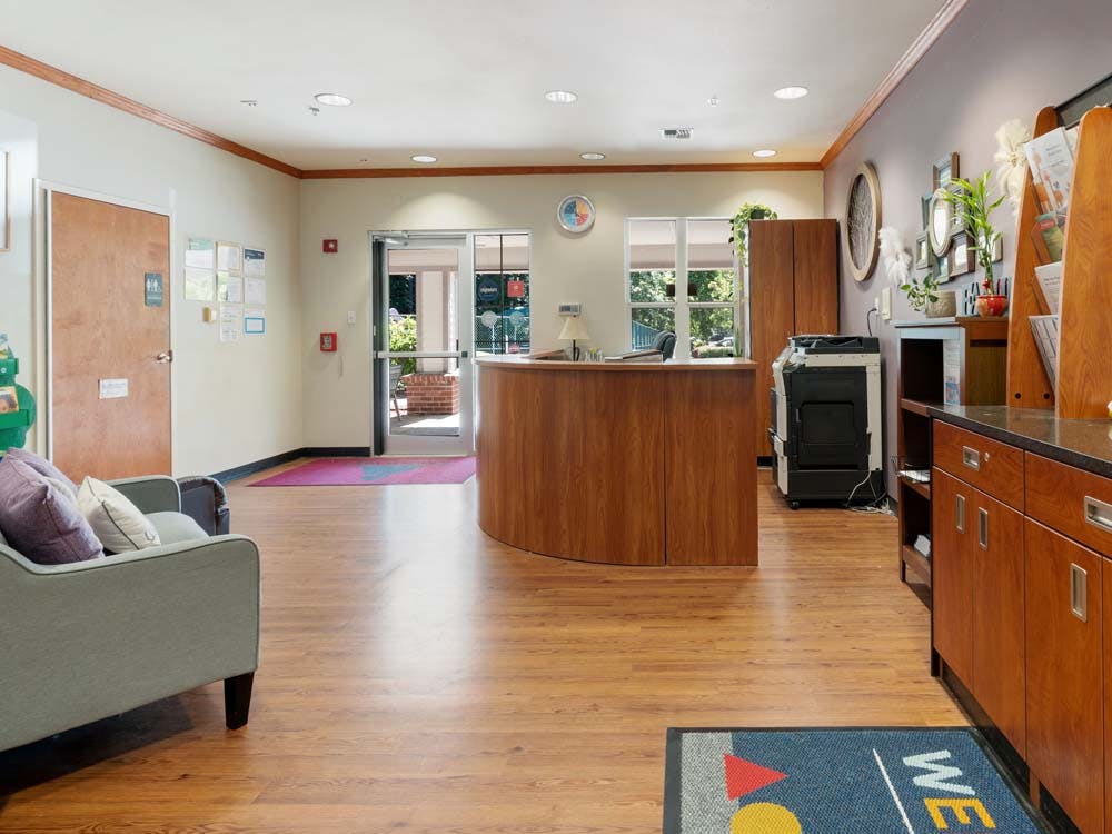 Lobby of a building with a wooden reception desk and seating area