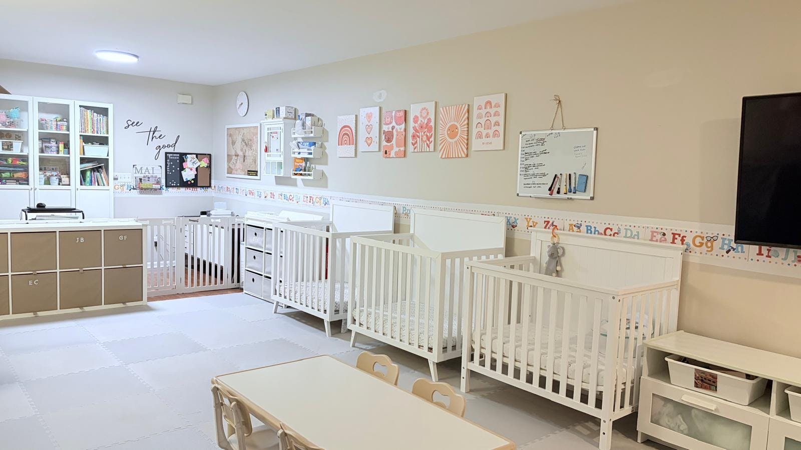 Daycare room with multiple cribs, storage shelves, and a child-sized table