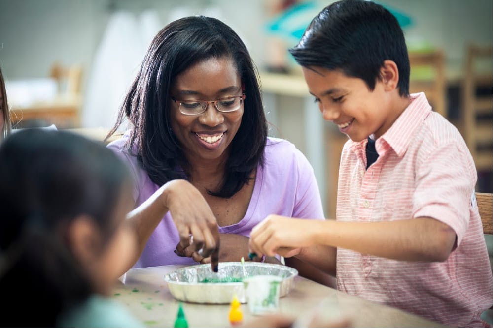 Person and child mixing ingredients in a bowl