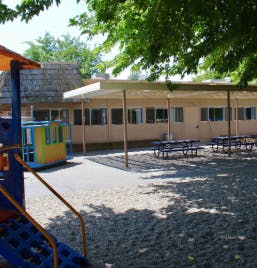 Playground with slides and a building with picnic tables