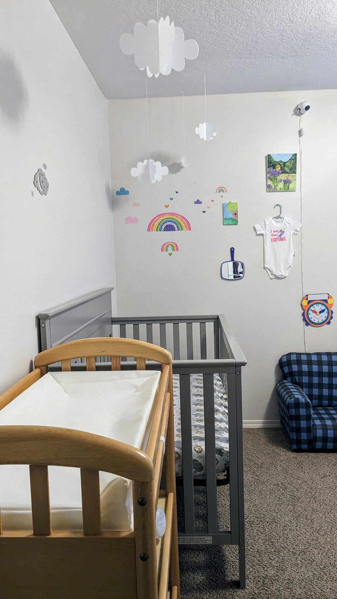 Crib and changing table in a child nursery decorated with rainbow wall decals