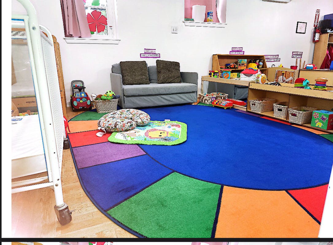 Playroom with a colorful rug, sofa, and shelves with toys