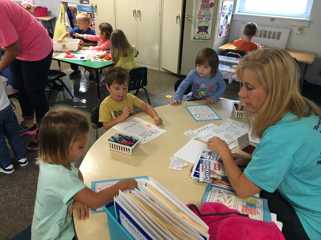 Adult and children at a table in a classroom