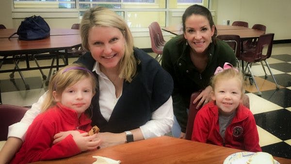 Two adults and two children smiling at a table